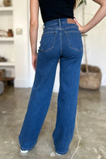 Person wearing blue jeans and a black top in an indoor setting