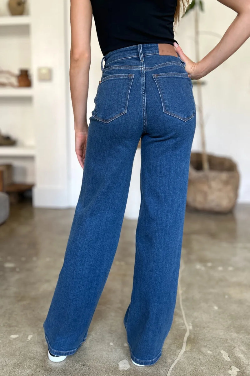 Person wearing blue jeans and a black top in an indoor setting