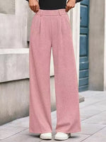 Person wearing pink wide-leg pants standing on a stone pavement.
