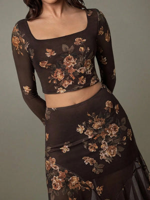 Woman wearing a dark floral outfit against a gray background