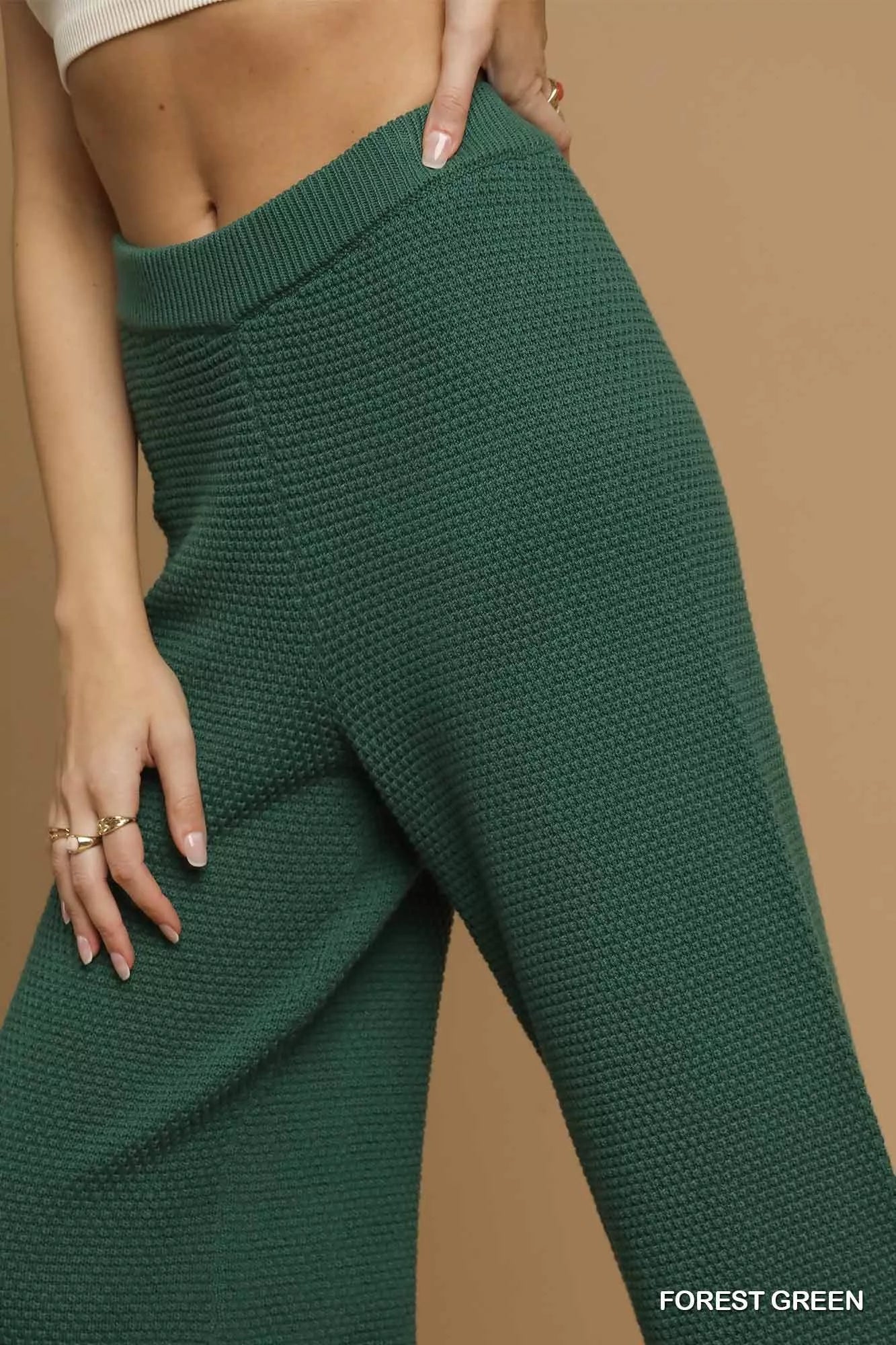 Green knitted pants on a beige background