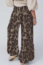 Person wearing leopard print pants on a plain background