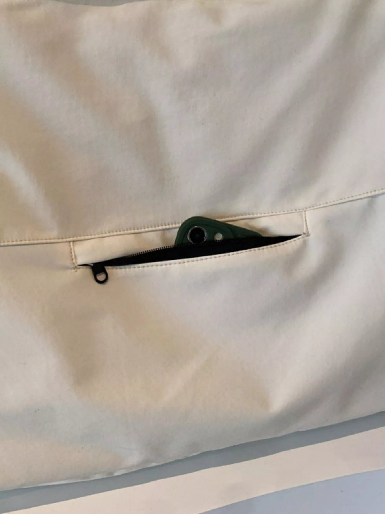 Close-up of a beige fabric with a zipper pocket