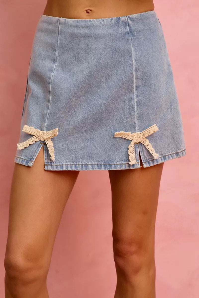 Denim skirt with lace trim on a pink background