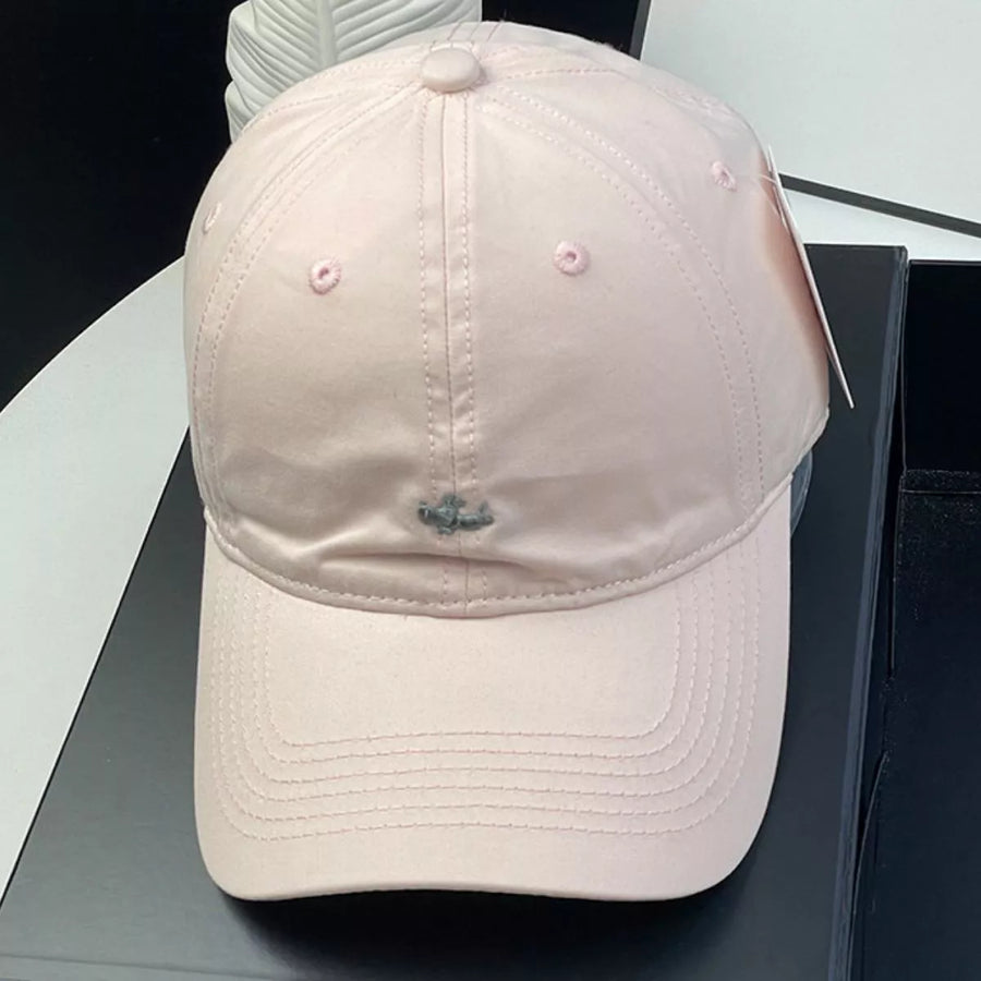 Pink baseball cap on a black surface with a tag attached