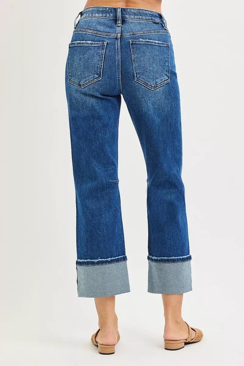 Blue jeans with a cuffed hem on a white background