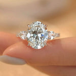 Diamond ring held on a finger with a blurred background
