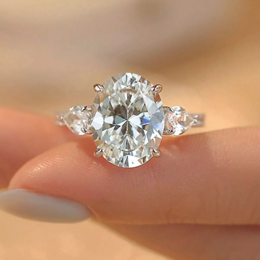Diamond ring held on a finger with a blurred background