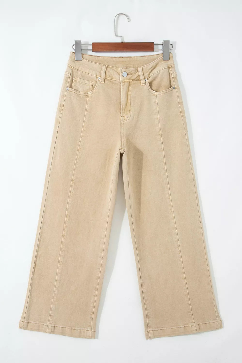 Beige pants on a hanger against a white background