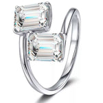 Silver ring with two emerald-cut diamonds on a white background