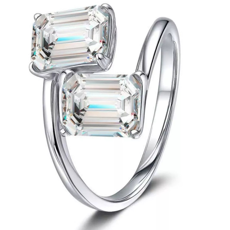 Silver ring with two emerald-cut diamonds on a white background