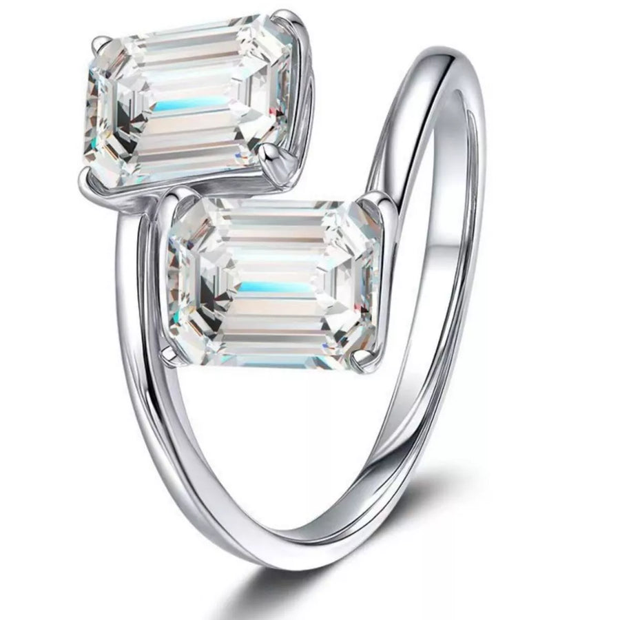Silver ring with two emerald-cut diamonds on a white background