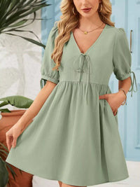 Woman wearing a green dress with a blurred indoor background
