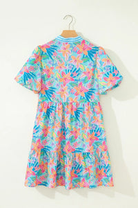 Colorful floral dress on a hanger against a white background