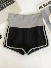 Black shorts with gray waistband on a white surface