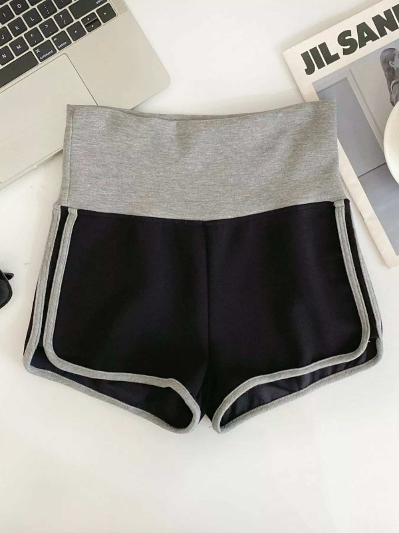 Black shorts with gray waistband on a white surface