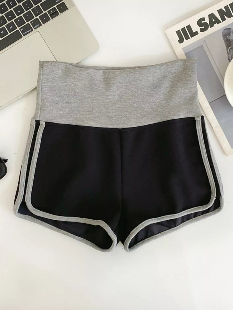 Black shorts with gray waistband on a white surface