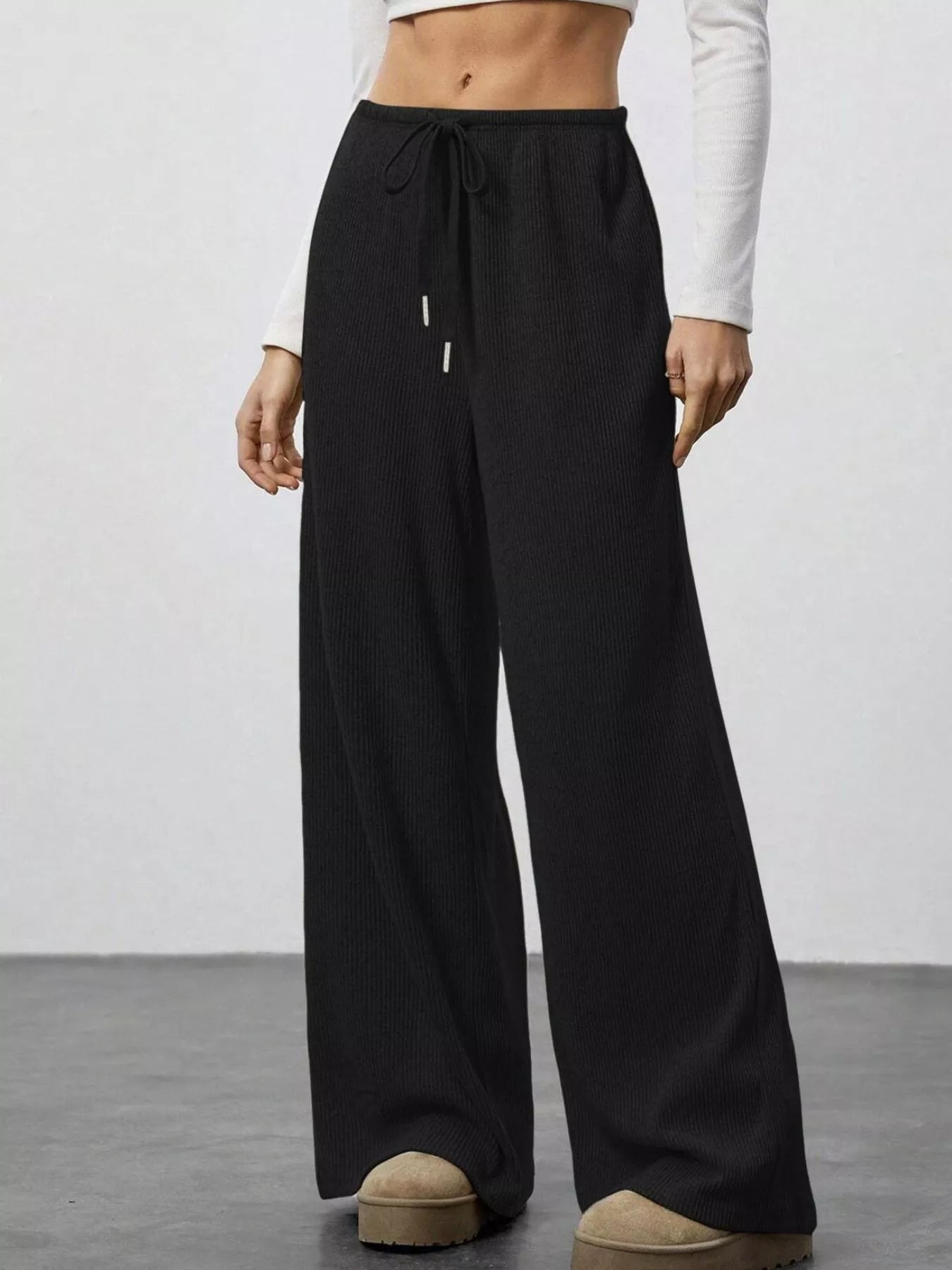Black wide-leg pants worn by a person on a plain background