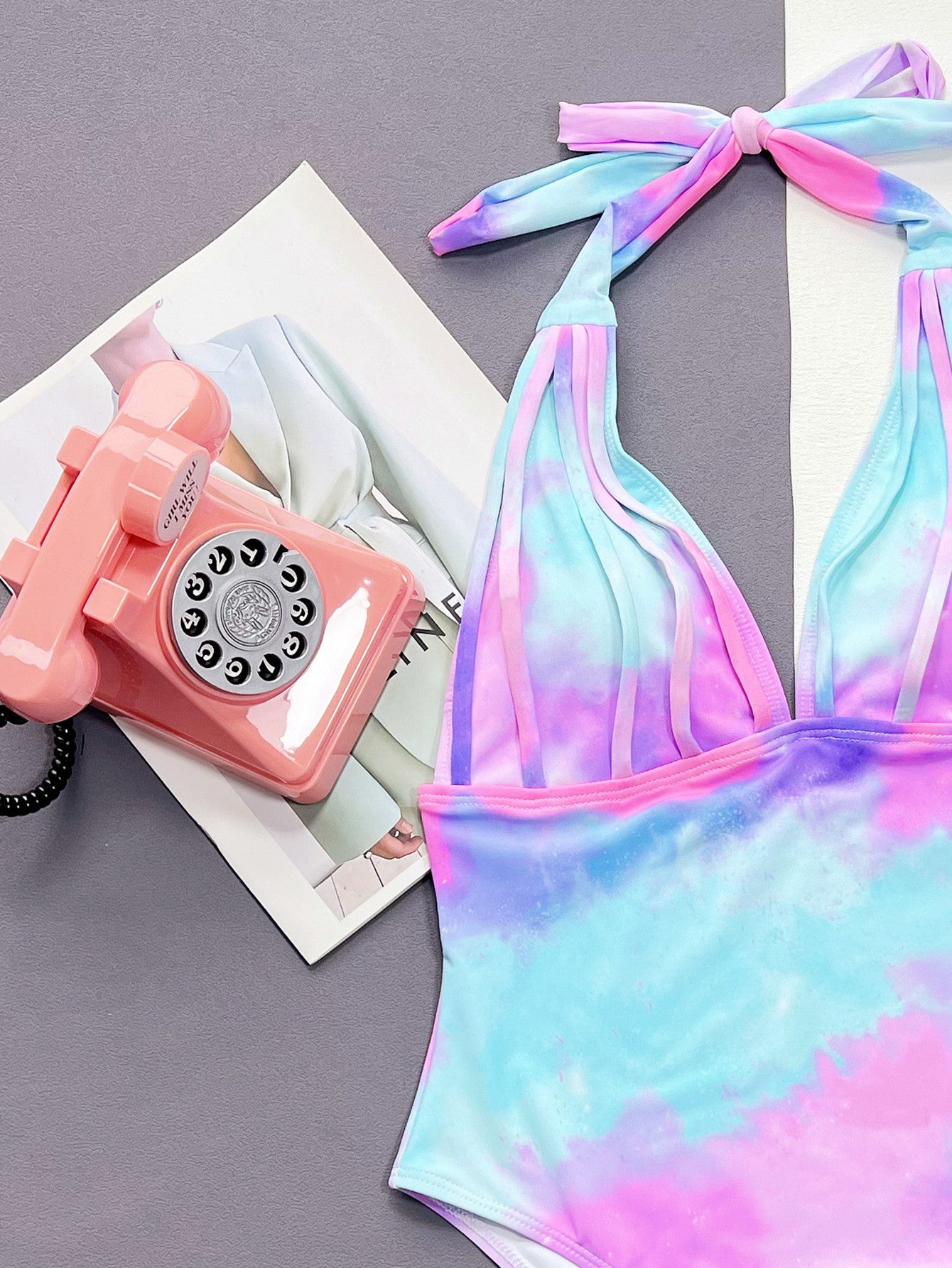 Tie-dye swimsuit with pink rotary phone on a magazine