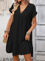 Woman wearing a black dress with a neutral background