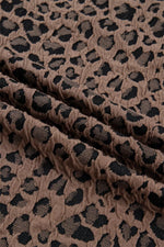 Close-up of brown fabric with black leopard print pattern