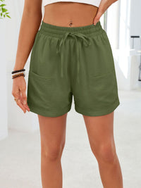 Person wearing green shorts with a white background