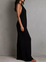 Person wearing a black halter neck dress against a plain background