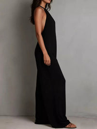 Person wearing a black halter neck dress against a plain background