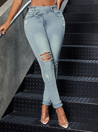Person wearing light blue distressed jeans on black steps