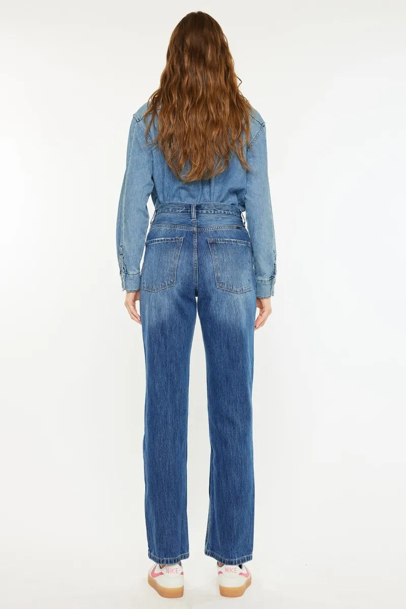 Person wearing a blue denim jumpsuit on a white background