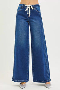 Blue wide-leg jeans with a drawstring waist on a light gray background