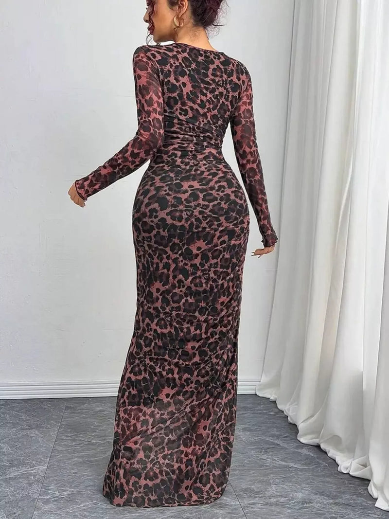 Person wearing a long, sheer dress with a leopard print pattern in a room with white walls and curtains.