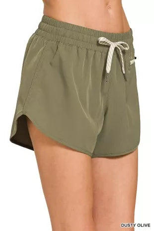 Olive green shorts with a drawstring on a white background