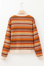 Orange and brown patterned sweater on a hanger against a white background