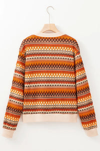 Orange and brown patterned sweater on a hanger against a white background