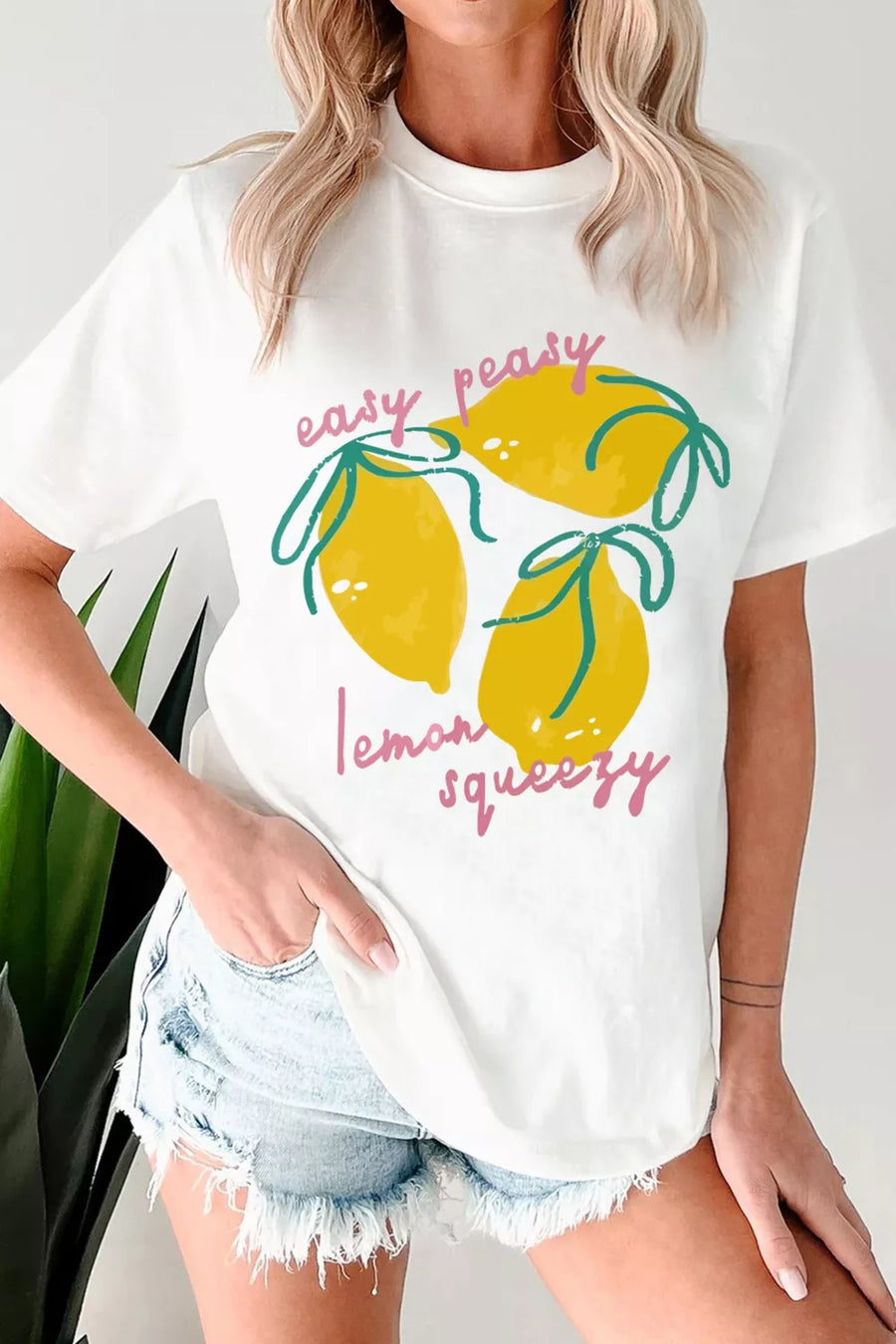 Person wearing a white t-shirt with lemon graphic and text