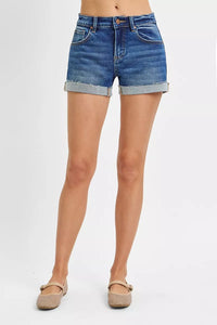 Denim shorts worn by a person on a white background
