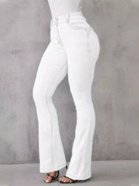 White flared jeans worn by a person on a gray background