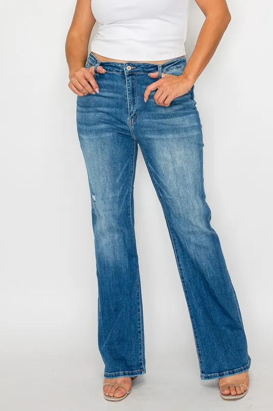 Person wearing blue jeans and a white top on a plain background