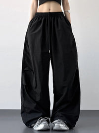 Person wearing black wide-leg pants with a plain background