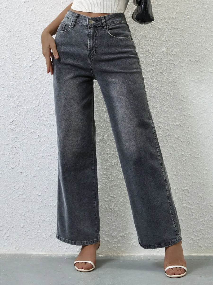 Person wearing high-waisted black jeans against a light gray background