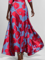 Woman wearing a red and blue floral dress on a plain background
