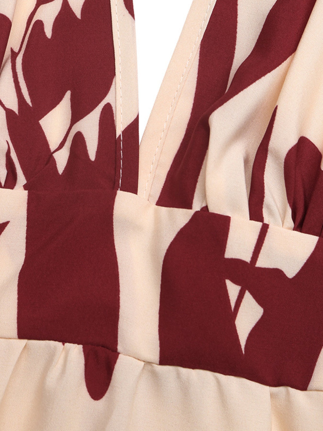 Close-up of a garment with maroon and beige abstract pattern