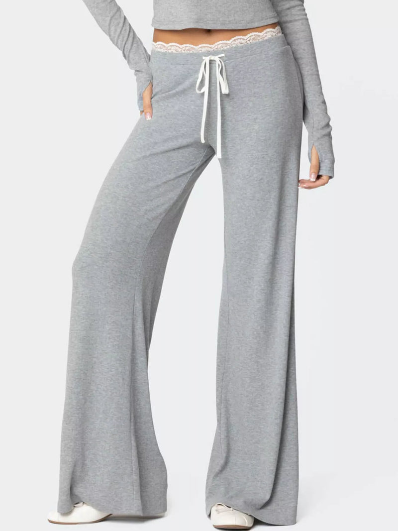 Gray lounge pants with a drawstring waist on a white background