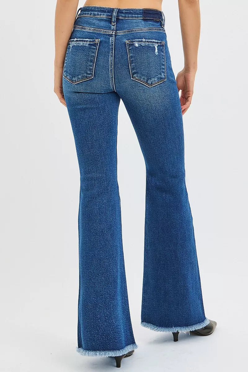 Blue flared jeans worn by a person on a white background