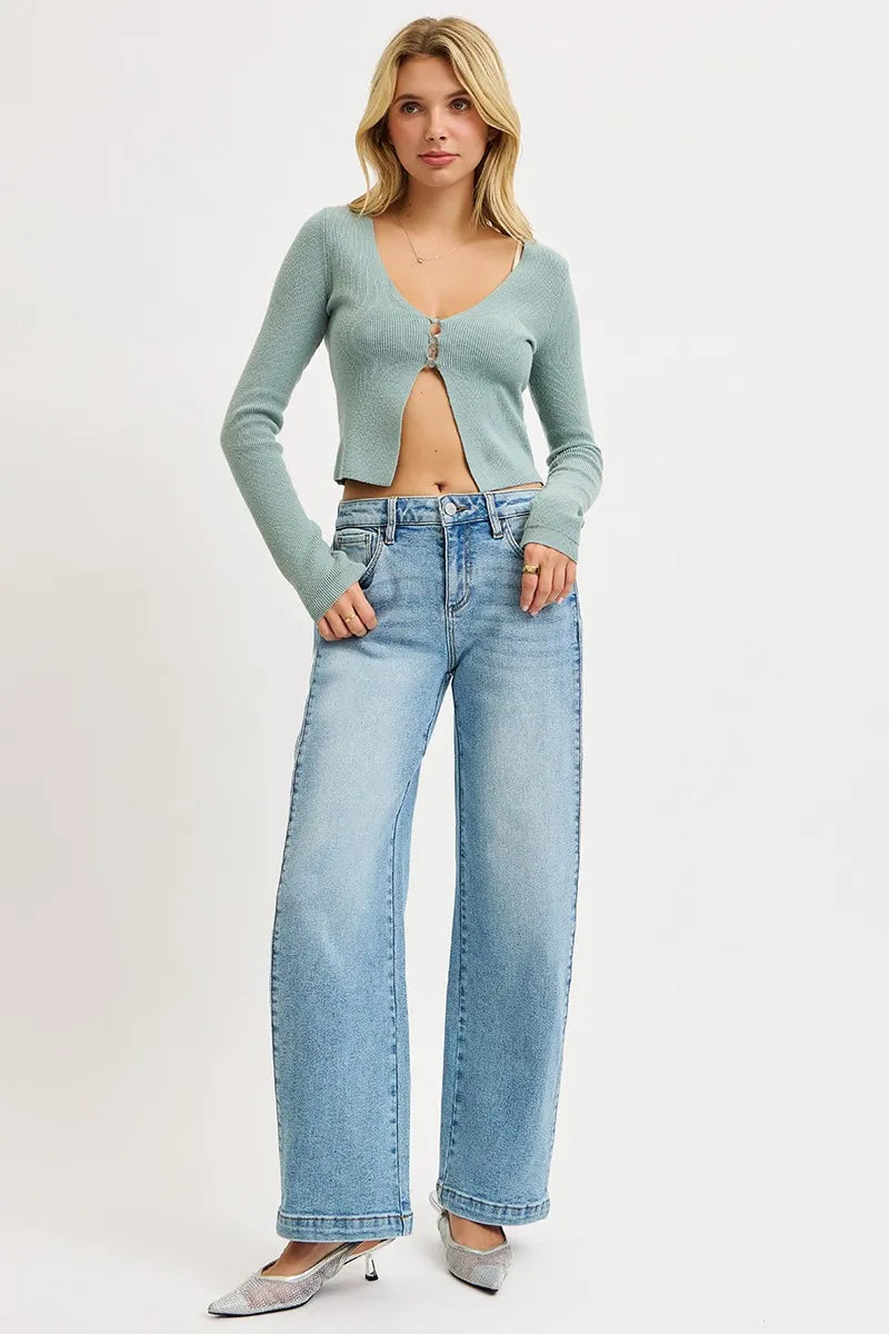 Woman wearing a light blue cardigan and jeans on a white background