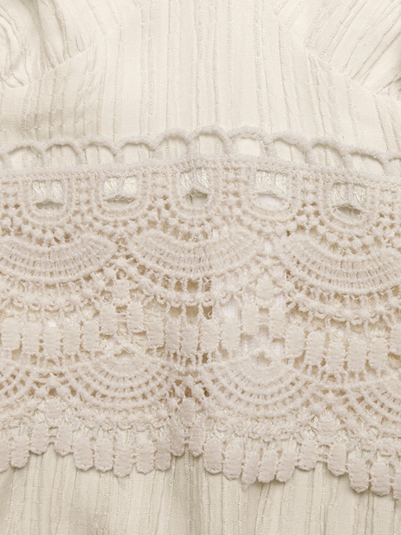 Close-up of intricate lace fabric with a neutral color palette.