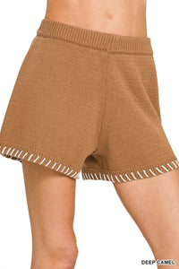 Brown knitted shorts with white trim on a white background