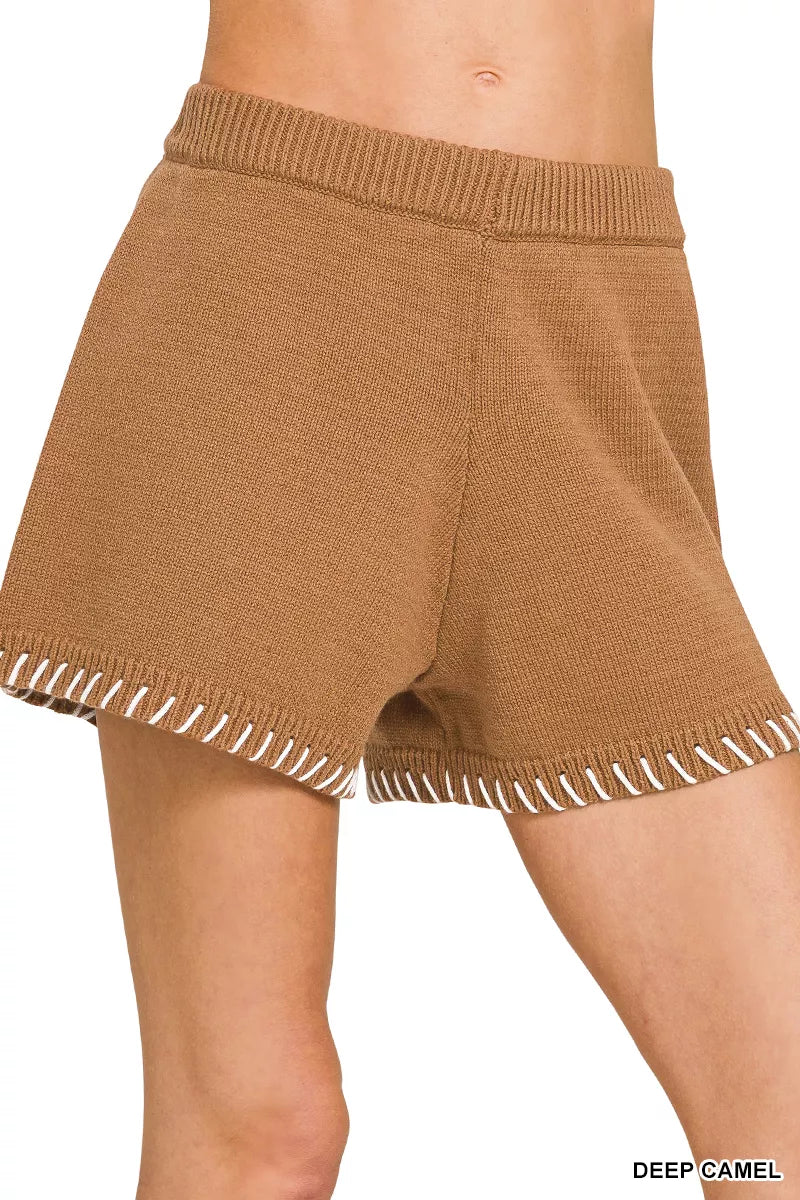 Brown knitted shorts with white trim on a white background