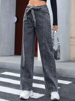 Person wearing high-waisted black jeans with a blurred background
